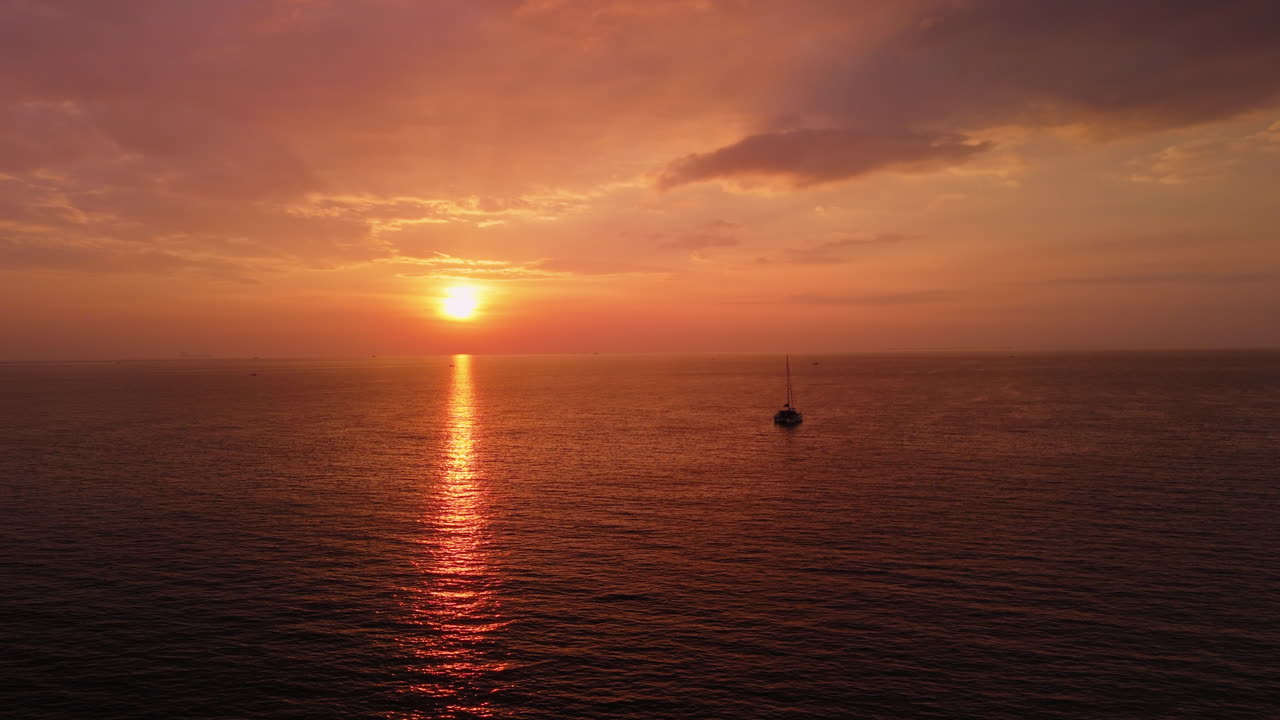 Sunset over the Ocean with a Sailboat