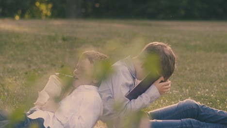 Junge-Sitzt-Mit-Fallendem-Buch-Im-Gesicht-Neben-Schlafendem-Klassenkameraden