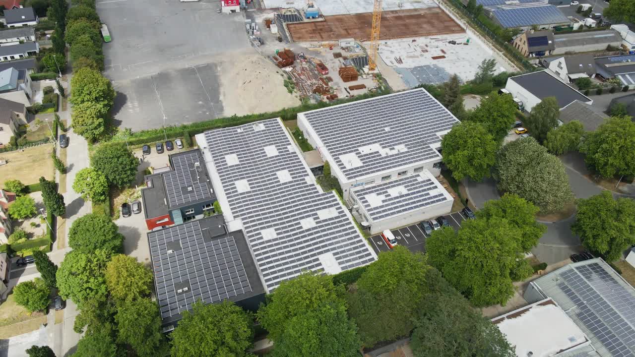 Beautiful aerial orbit of a sustainable industrial building with photovoltaic solar panels covering the rooftop