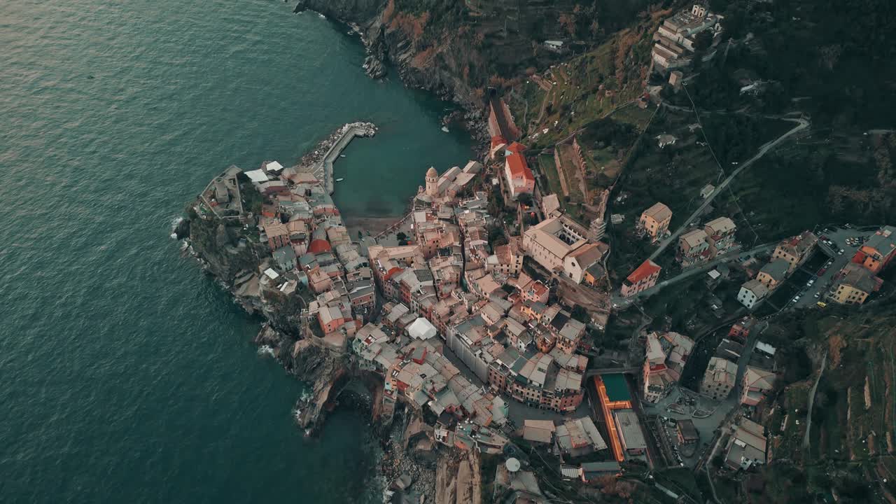 Aerial approaching flyover of Vernazza, Italy, bathed in soft sunset light