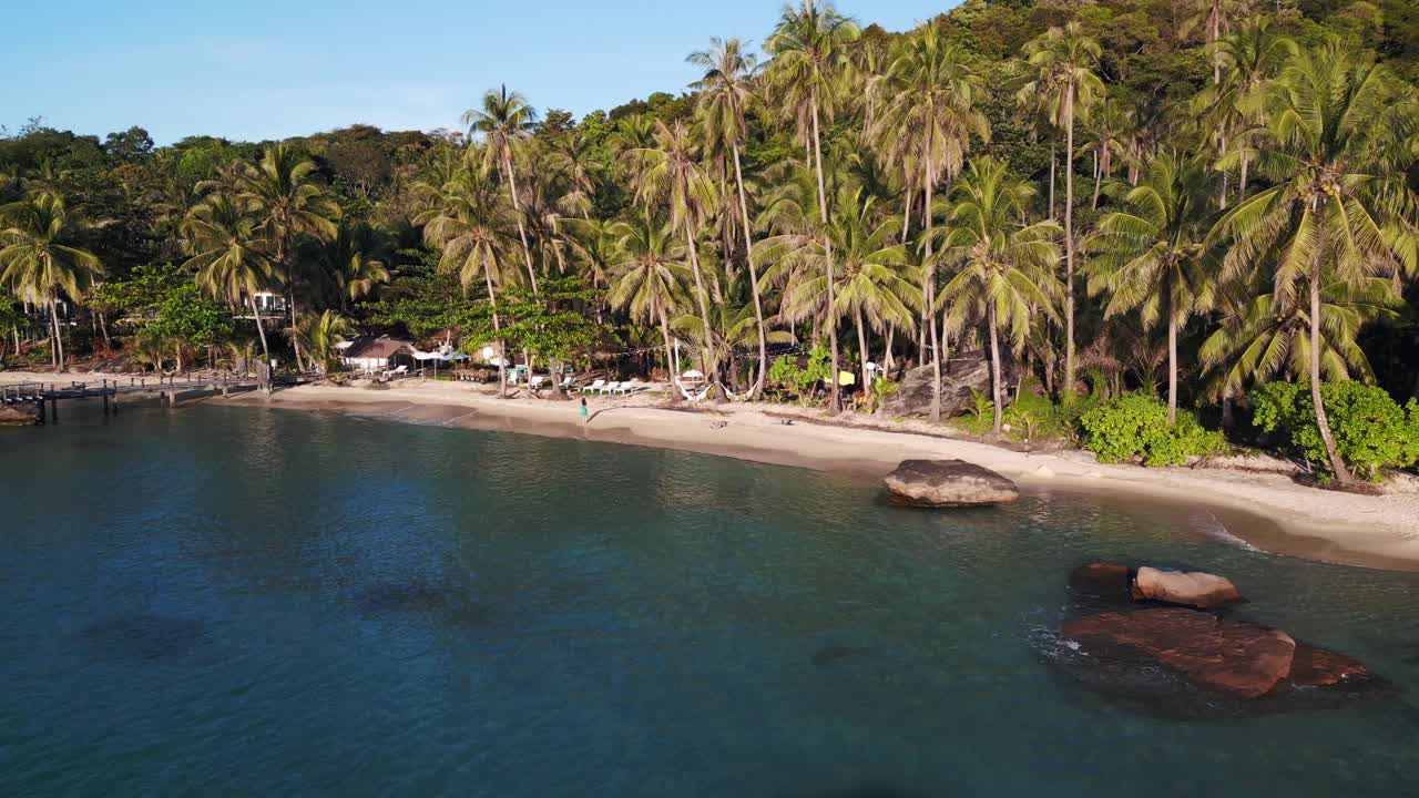 la chica está sola con un vestido verde a lo largo de la playa