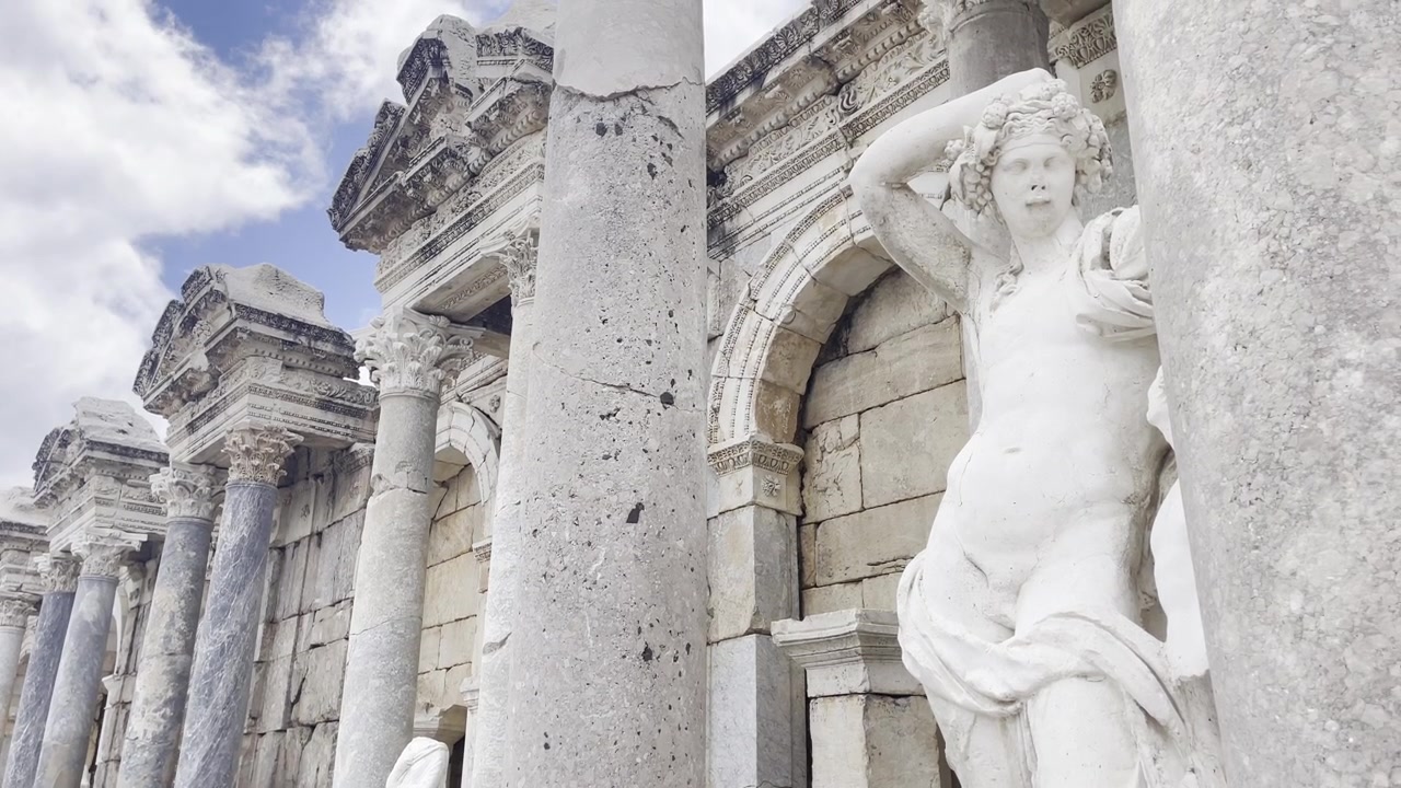 Panoramica ravvicinata di statue di marmo finemente intagliate e pilastri strutturali all'interno della casa della fontana del Ninfeo Antonino a Sagalassos, Turchia.