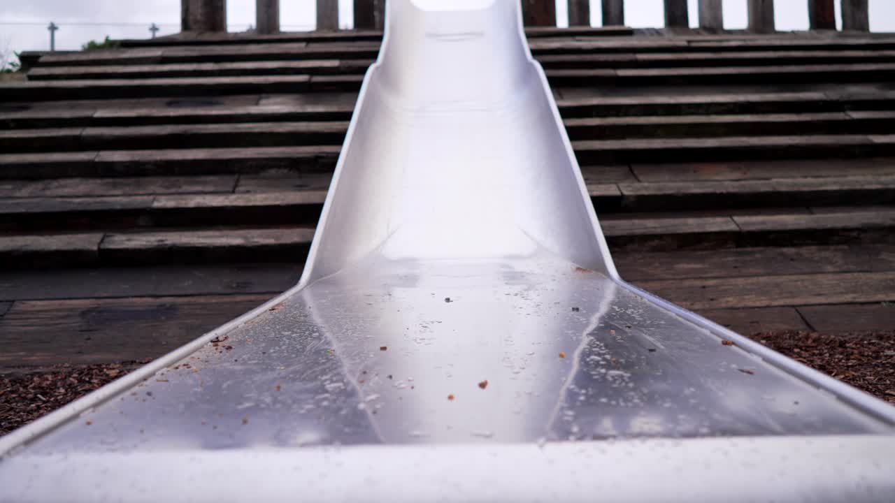 Looking up at the top of a metallic slide in a playground, symbol of bravery, courage, thrill, adventure, stress, and excitement