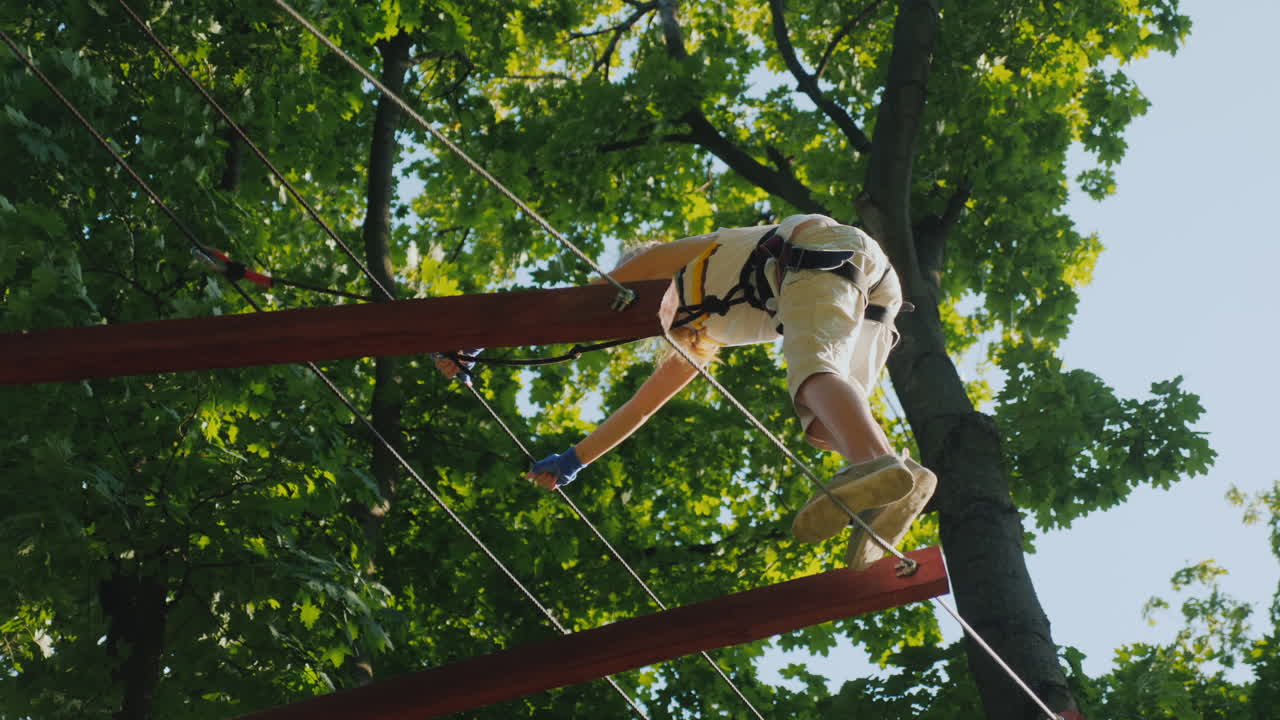 un niño valiente da pasos en un cable escalonado a una altura que supera el concepto de miedo