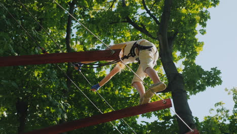 a brave child takes steps on a staggered cable at a height overcome fear concept