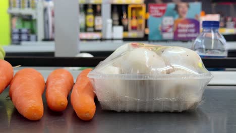 fresh mushrooms and carrots at grocery checkout