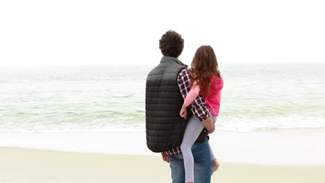 father and daughter looking at the beach