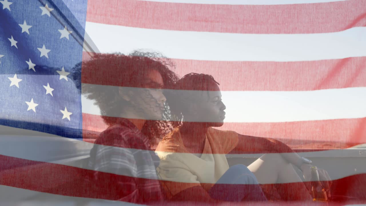 animación de la bandera estadounidense ondeando sobre una pareja de raza mixta en la playa junto al mar