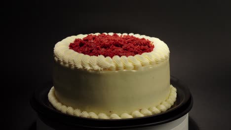 Pastel-De-Terciopelo-Rojo-Delicioso-Manjar-Sabroso-En-Una-Mesa-Giratoria-Fondo-Negro-Guarnición-Roja-En-La-Parte-Superior-Crema-Mantequilla-Afuera