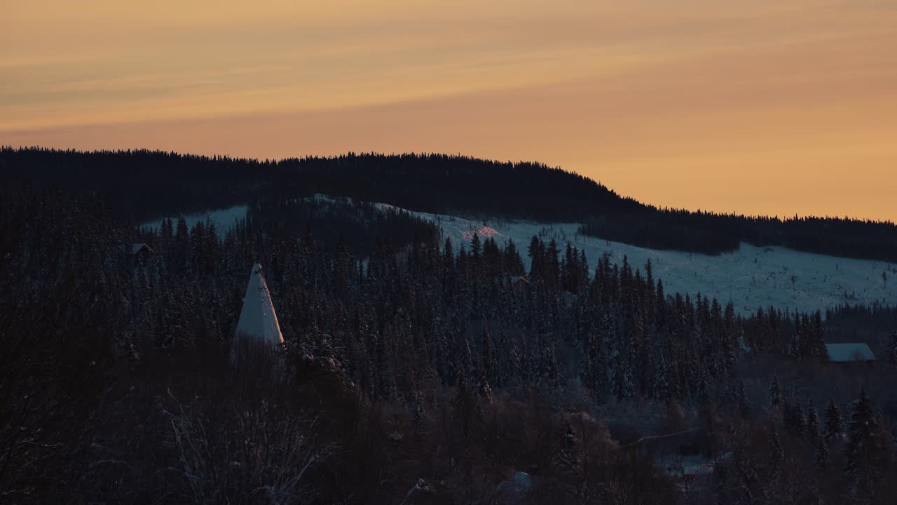 tiro de coníferas a lo largo de la ladera montañosa cubierta de nieve blanca en beitostolen, pueblo en el municipio de oystre slidre en el condado de innlandet,valdres, beito, noruega con puesta de sol