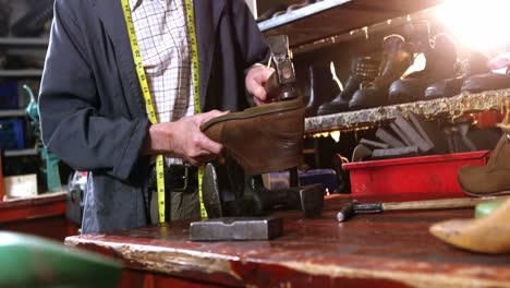 zapatero golpeando un zapato