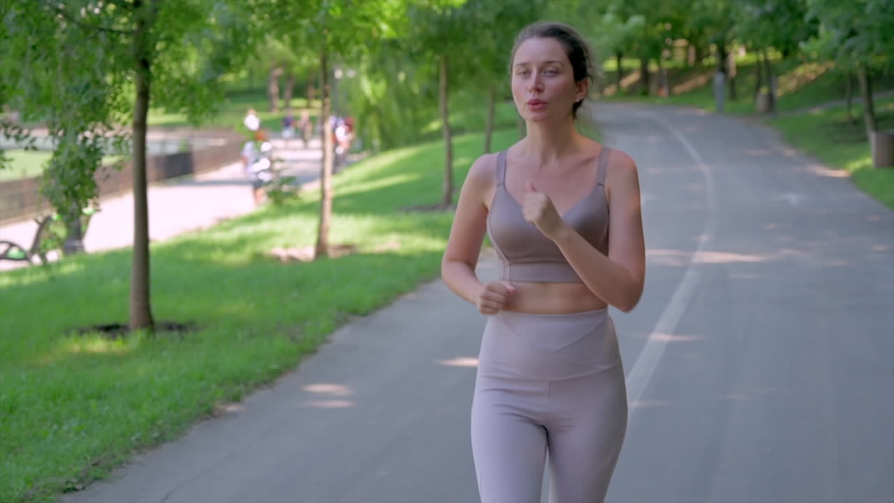 Woman in beige sportswear working out in the park