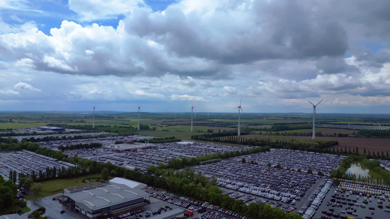 large parking lot full of cars near a wind farm and countryside in Germany. Fabulous aerial view flight panorama overview drone