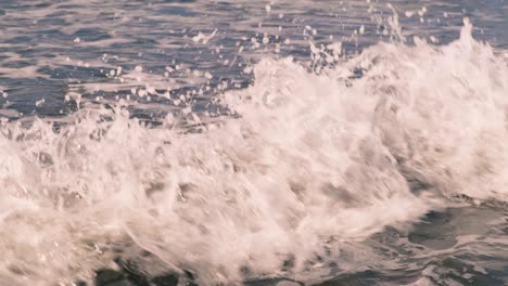 slow motion of bubbling foaming ocean waves off the coast of the island of bali in indonesia into the sunny. two waves collide crashing into each other creating splashes of the indian ocean. 4k