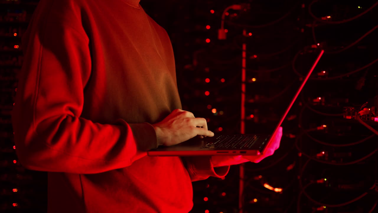 Close up of a man trying to fix an error on a computer in a server room
