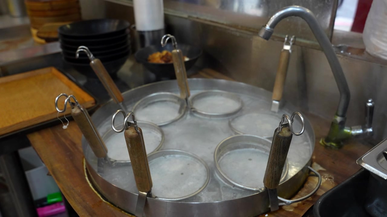 Steam rising from a traditional steamer preparing food in an authentic Taiwanese restaurant kitchen