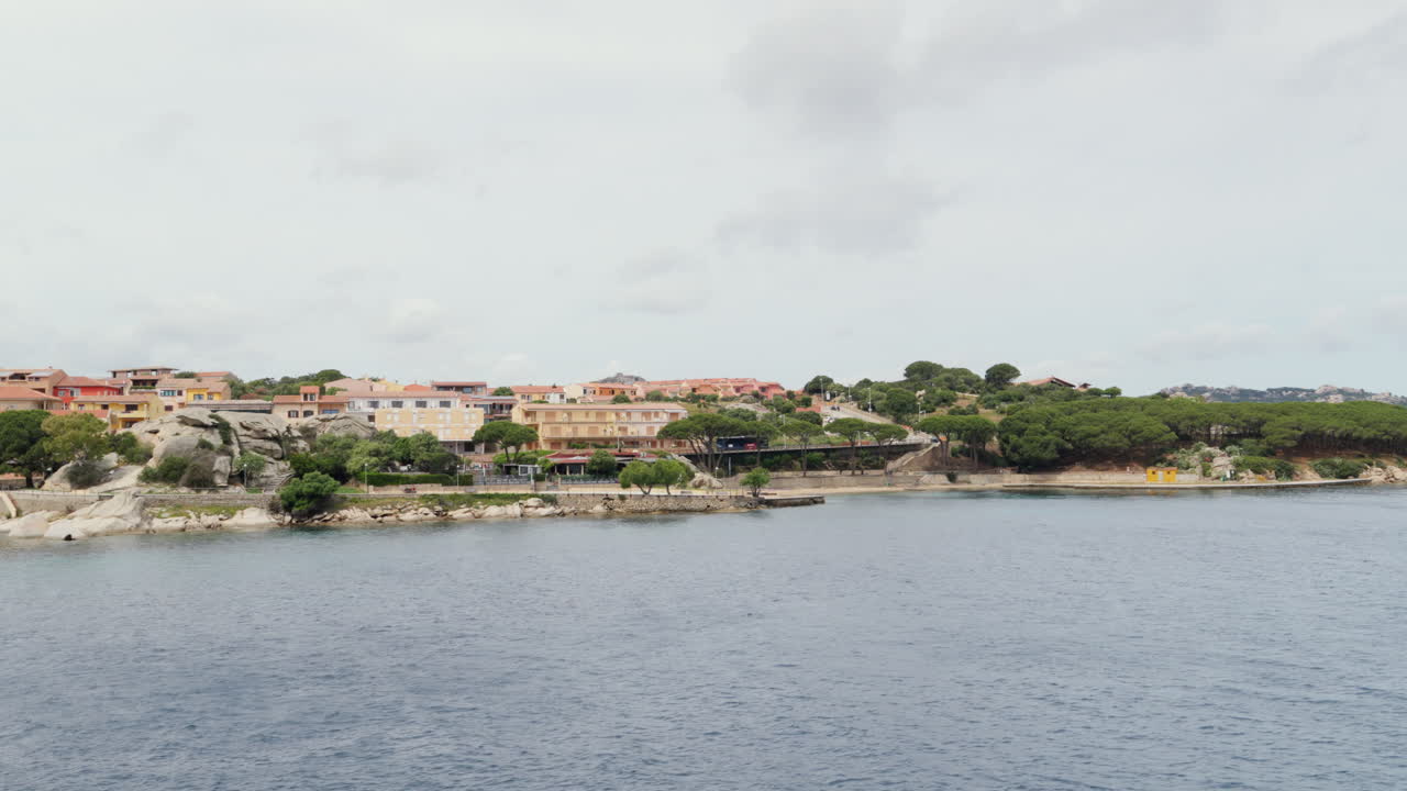 해안 건물과 울창한 초록색으로 조용한 사르데니아 해경