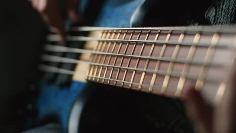 close-up of someone playing a blue bass guitar