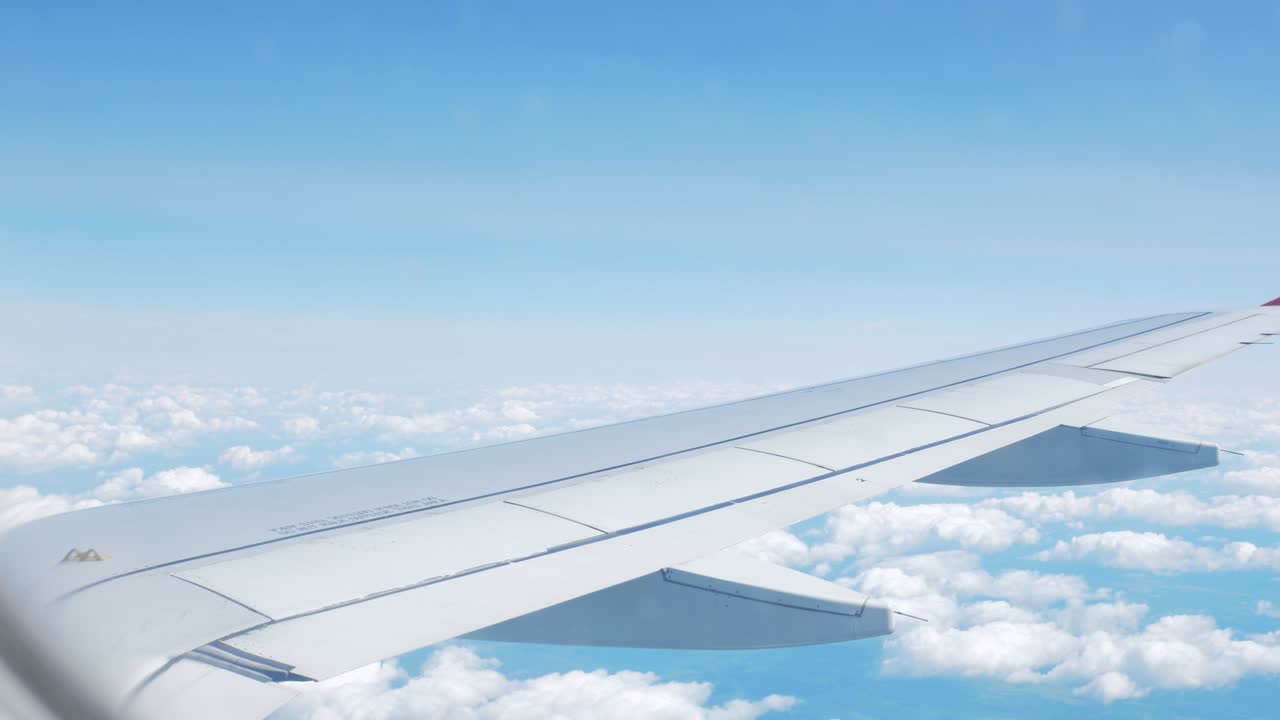 비행기의 창문에서 날개와 구름을 볼 수 있습니다.