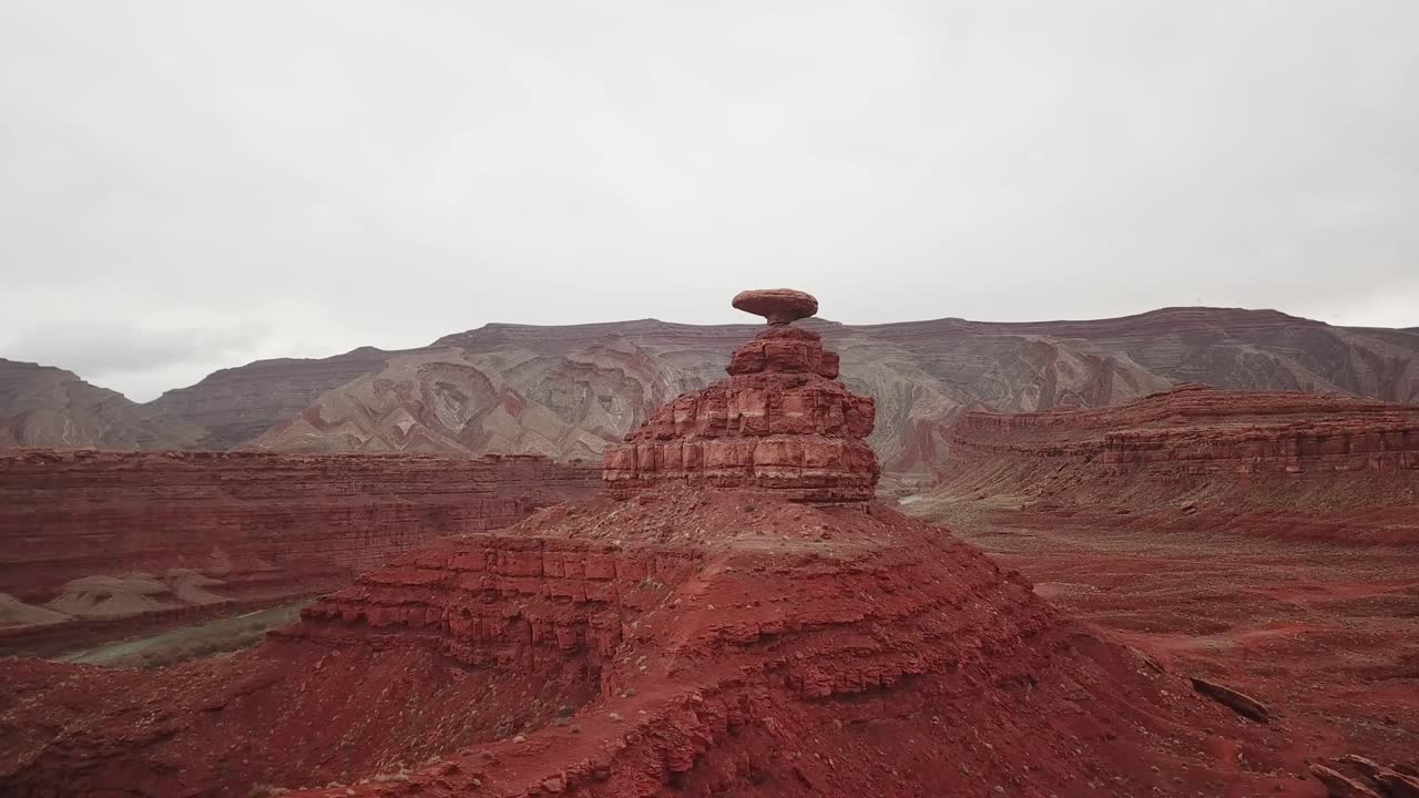 Orbiting aerial view of a red rock formation in Utah's vast desert