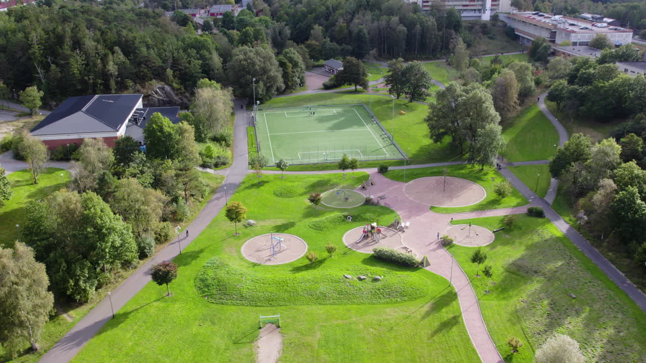 Aerial view of park area in Gårdsten, Gothenburg, Sweden featuring football field, playground and green landscape. Urban recreation space surrounded by trees and residential buildings