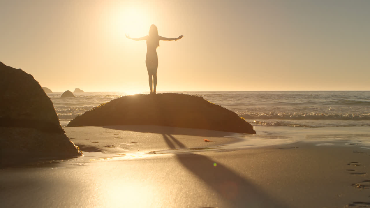 mujer en forma de pie con los brazos cruzados en la playa 4k
