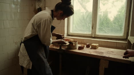 beautiful woman sculpting clay pot in pottery