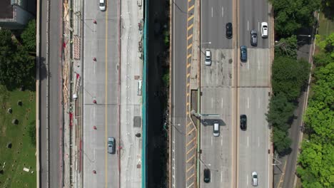 Pleasing-aerial-of-cars-on-highways-with-construction-materials,-4K-60fps