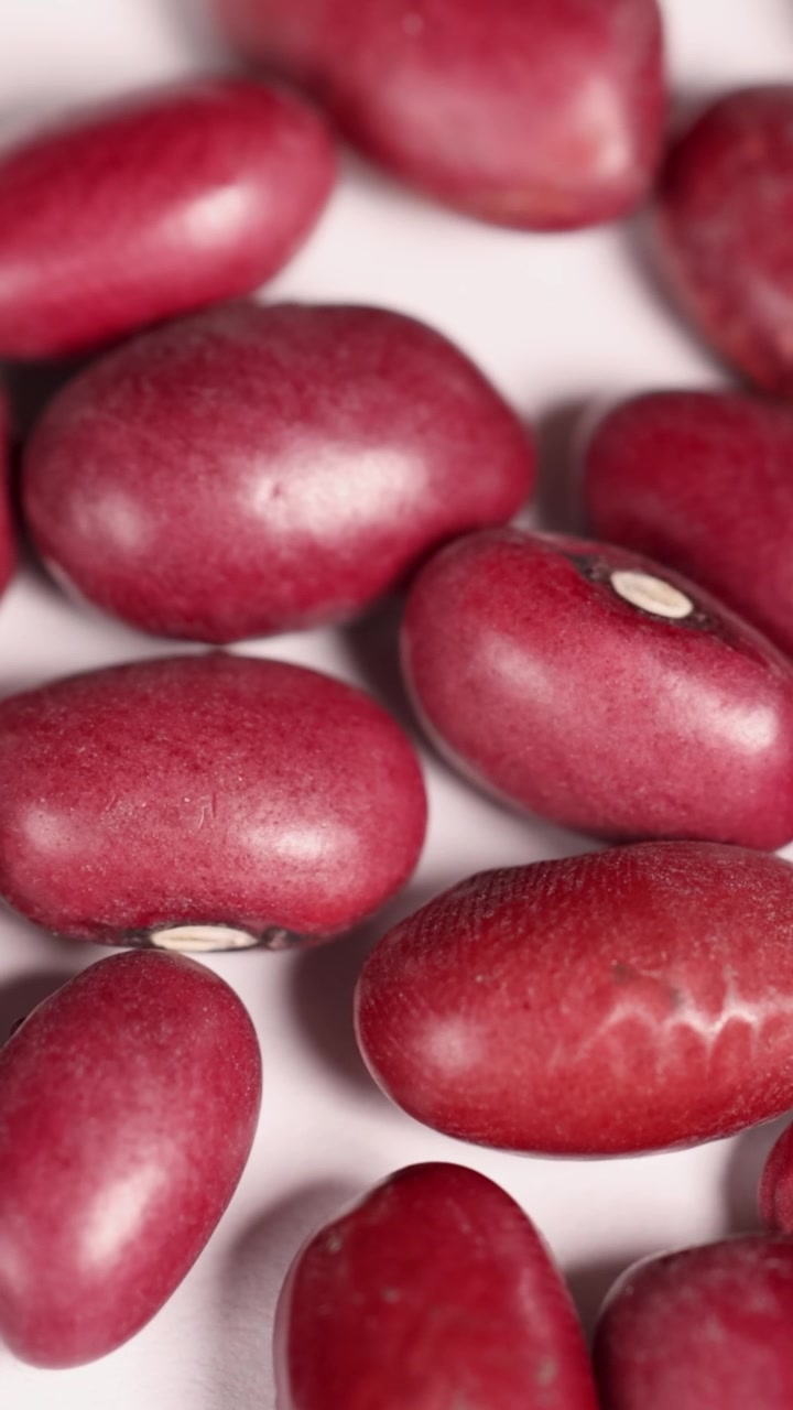 Close-up video of red bean seeds shifting slightly, highlighting texture and color under bright lighting