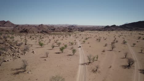 car on sandy road in rugged namibian landscape, wild african experience