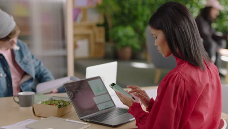 Hermosa-Joven-Mujer-De-Negocios-De-Raza-Mixta-Usando-Un-Teléfono-Inteligente-En-La-Oficina-Enviando-Mensajes-De-Texto-Navegando-Por-Mensajes-En-Un-Teléfono-Móvil-Compartiendo-Ideas-Profesionales-Disfrutando-De-Un-Lugar-De-Trabajo-Moderno