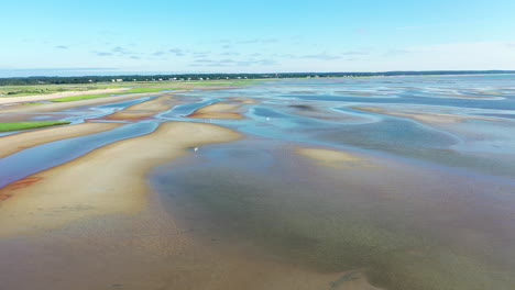 Cape-Cod-Bay-Aerial-Drone-Footage-of-Bay-Side-Beach-at-Low-Tide-with-Sand-Dunes-and-People-Walking-in-Ocean