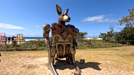 child observing large kangaroo sculpture outdoors