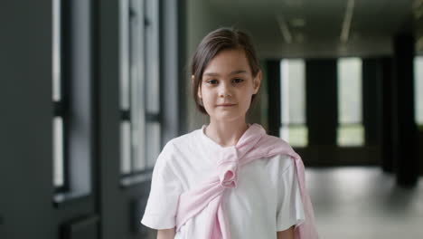 schoolgirl looking at camera in school corridor.