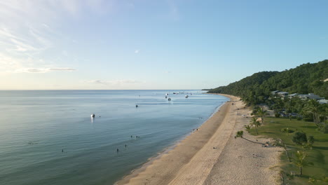 Tangalooma-Moreton-Island-beach-landscape,-aerial-drone-fly-sea-skyline-forested-hill-area-in-coastal-travel-destination,-Australia