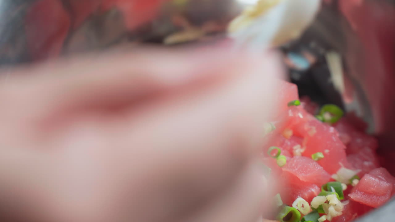 espolvorear cebollas verdes y maui picadas sobre atún crudo cortado en cubitos y salmón pescado