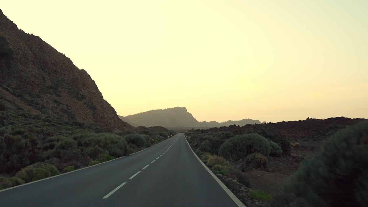 conduciendo por una carretera de asfalto a través del paisaje volcánico de teide, tenerife
