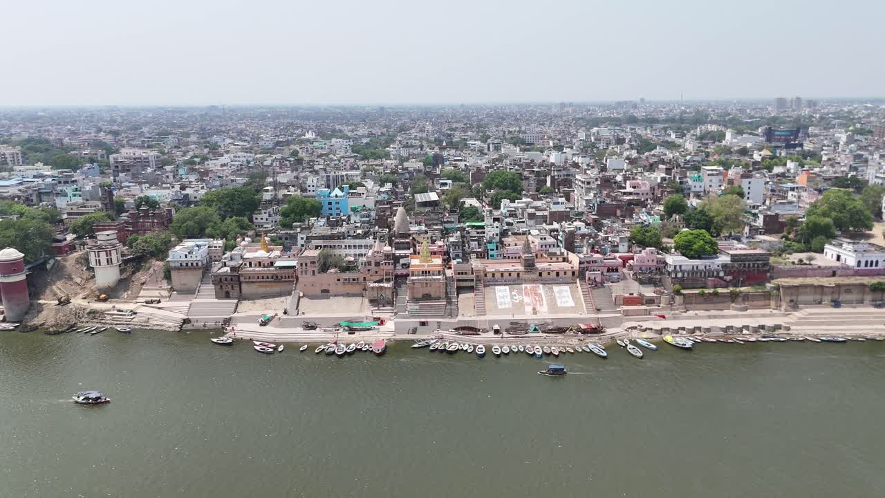 Aerial perspective of the Ganges River flowing through Varanasi, framed by the densely packed buildings and vibrant ghats of this ancient city.