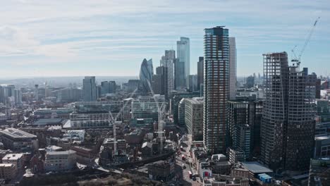 close up aerial dolly forward drone shot towards city of london business district from shoreditch sunny day