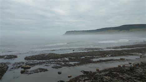 Low-Establishing-Aerial-Drone-Shot-on-Misty-Morning-of-North-Yorkshire-Coast-Near-Robin-Hood's-Bay