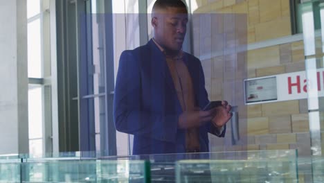 Animation-of-data-processing-over-african-american-businessman-using-smartphone