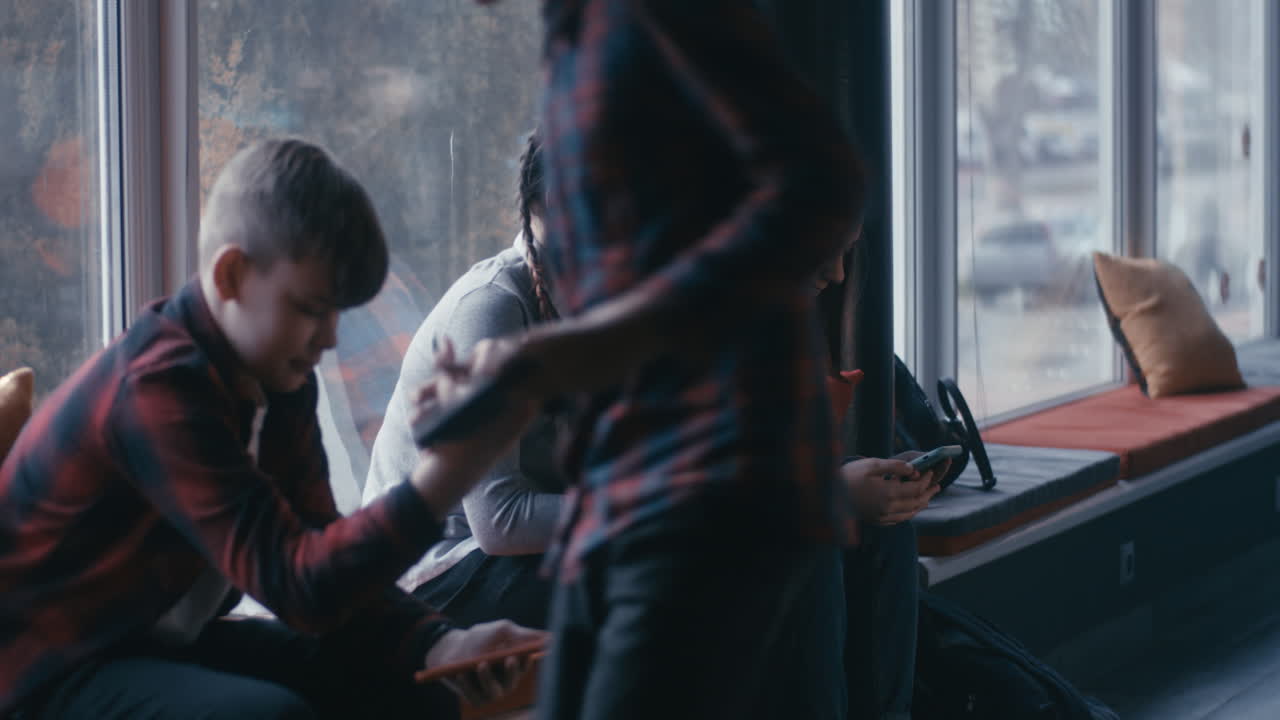Teenagers using smartphones in a cafe