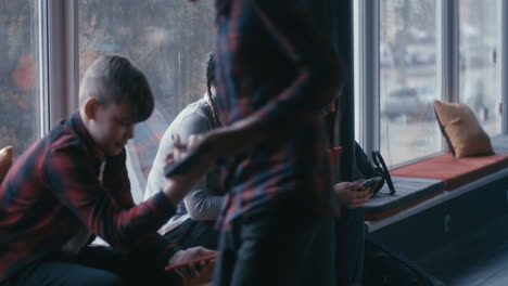 teenagers using smartphones in a cafe