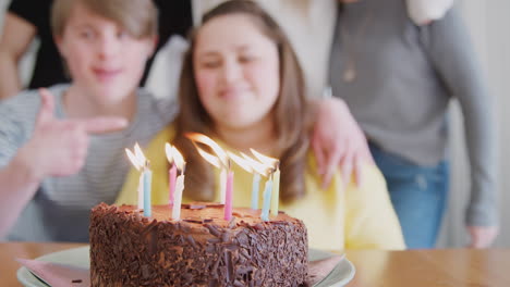 young downs syndrome couple celebrating birthday at home with cake