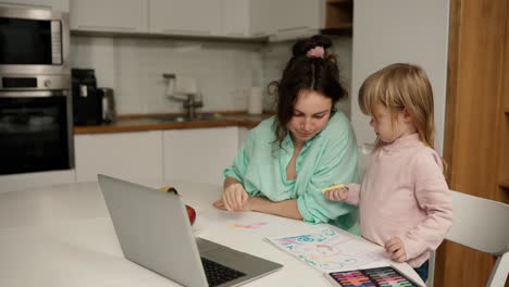 Hermosa-Mamá-Ayuda-A-Su-Pequeña-Hija-Con-Su-Dibujo.