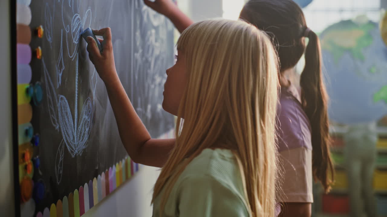 Children drawing on a chalkboard in a classroom