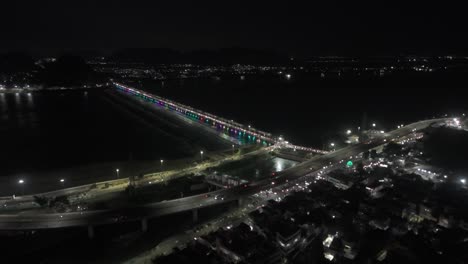 aerial views of vijayawada at night offer a breathtaking spectacle. the krishna river, illuminated by the prakasam barrage a bustling metropolis near amaravati, the capital of andhra pradesh