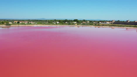 The-historical-town-of-Aigues-Mortes-in-the-Camargue,-France-during-a-sunny-summer-day-which-is-located-next-to-a-pink-salt-lake