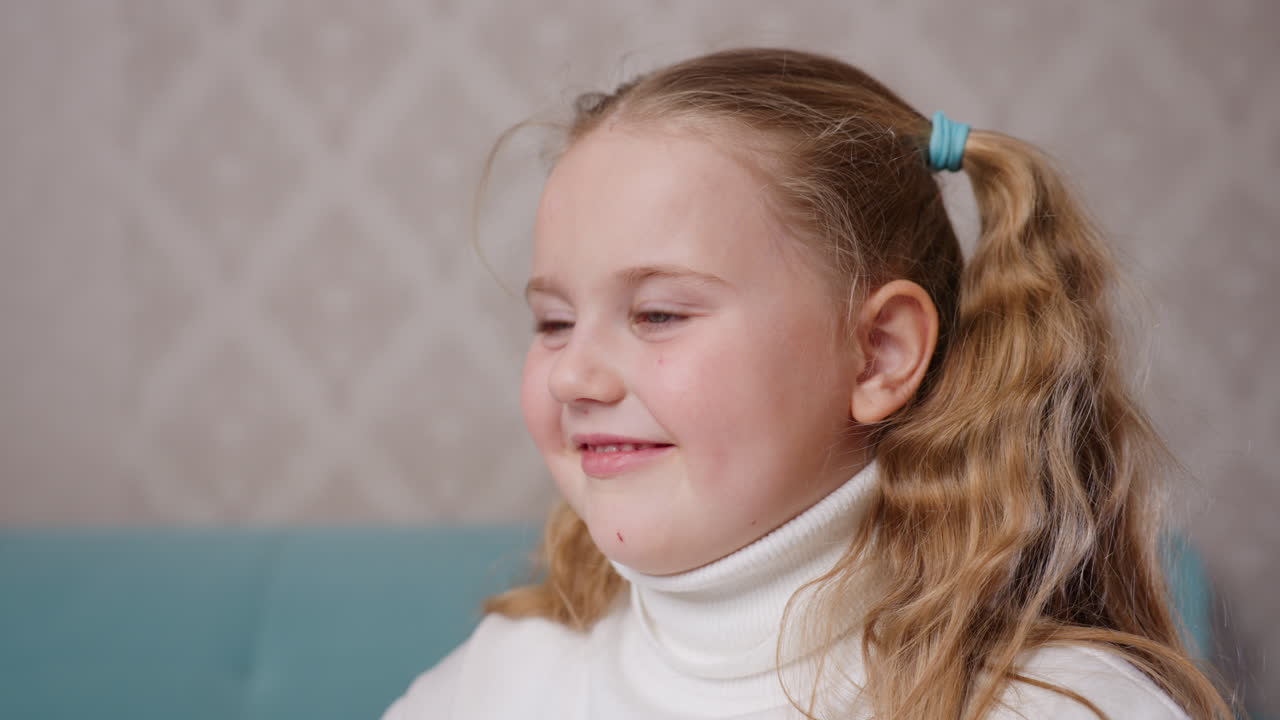 Close up portrait of girl with blonde hair in ponytails wearing white turtleneck looking attentively with serious expression indoors, capturing emotion, childhood, learning, concentration, innocence