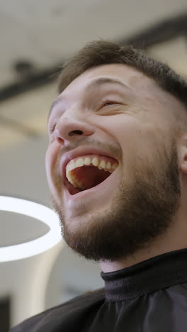 man laughing during a haircut